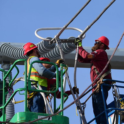 Two men working on overhead transmission powerlines.