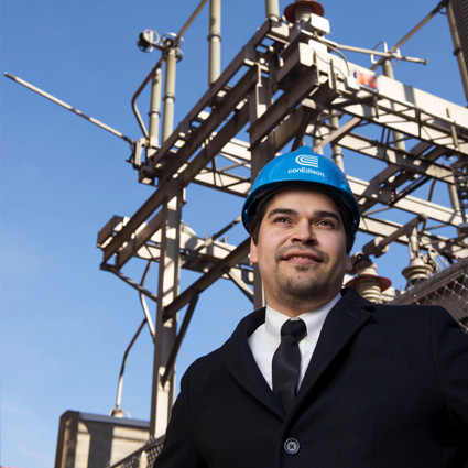A man is standing near a transmission station.